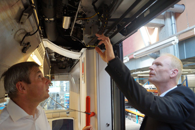 Системотехник VAG Роберт Майер и эксперт фирмы igus® Вернер Пехер тестируют дверную систему с применением кабелей chainflex® и э-цепи e-chain®.